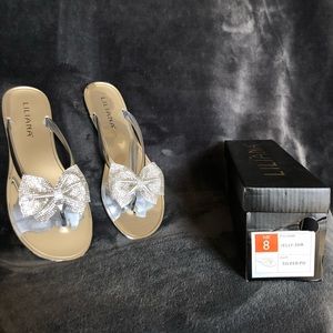 silver sandals with a bedazzled bow